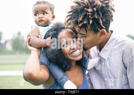 Happy black family having fun dans un parc en plein air - Mère et père de leur fille profiter du temps ensemble dans une journée de semaine