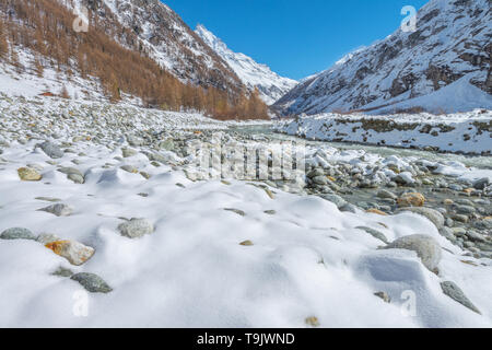 Des sommets enneigés, des tours de crête au-dessus de la vallée. Alpes suisses. La neige, la vallée de la rivière glaciaire-fed, neige fraîche sur le lit de la rivière des roches. Banque D'Images