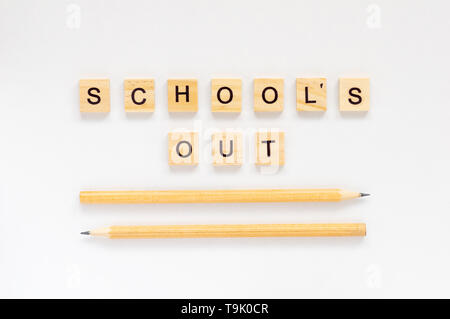 L'école est finie. L'inscription en lettres en bois sur un fond blanc. Crayons de couleur sur fond blanc Banque D'Images