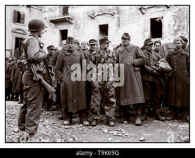WW2 Archive armée allemande de la Seconde Guerre mondiale prisonniers groupe disparate de la Wehrmacht en uniforme de l'armée allemande détenus gardés par un jeune soldat GI américain à Anzio Italie 1944 Banque D'Images