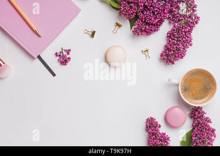 La composition créative avec des accessoires féminins, belles fleurs lilas, café et macarons, vue du dessus Banque D'Images