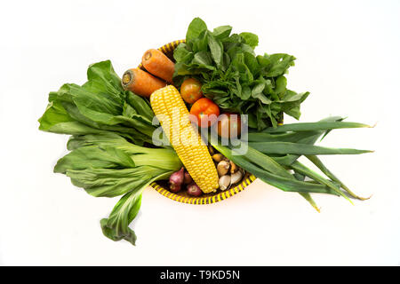 Vue de dessus de divers légumes frais dans un panier de bambou isolé sur fond blanc Banque D'Images