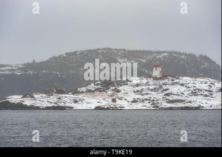 Phare sur la rive couverte de neige Banque D'Images