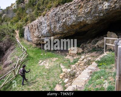 Middle-aged female hiker portant un sac à dos et des bâtons de marche La marche vers la caverne à la Vierge de la Cueva, mont Oroel, Jaca, Espagne Banque D'Images