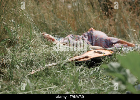 Guitare et dormir dans la nature fille hippie sur journée d'été. photo avec copie espace. Banque D'Images