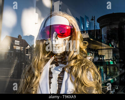 Squelette humain portant des lunettes rouge et perruque dans une vitrine Banque D'Images