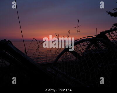 Magnifique coucher de soleil avec des casiers à homard en silhouette d'une plage camping sur l'Île Miscou, Nouveau Brunswick, Canada Banque D'Images
