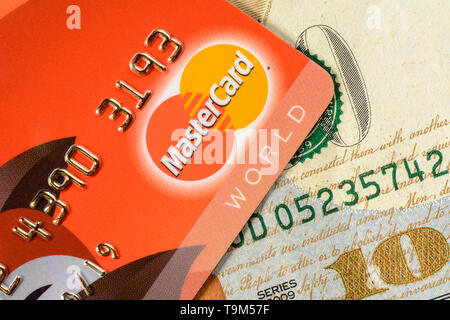 Lviv, Ukraine - 26 Avril 2019 : une carte rouge avec un logo MasterCard est placé sur un one hundred dollar banner close-up 2020 Banque D'Images