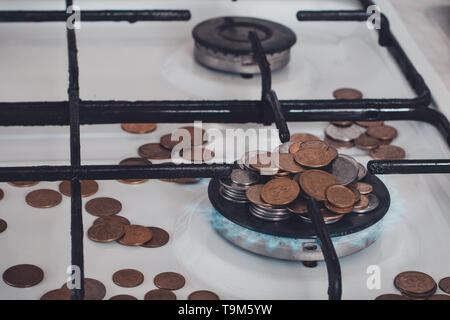 Flammes bleues de la combustion de gaz naturel d'une cuisinière à gaz sur un arrière-plan de la monnaie. 2019 Banque D'Images