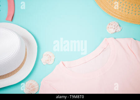 T shirt femme rose, blanc et beige des chapeaux et les coquillages sur fond de menthe pastel. Mode de @summer de la plage, vacances, boutique, magasin de vêtements de concept. F Banque D'Images