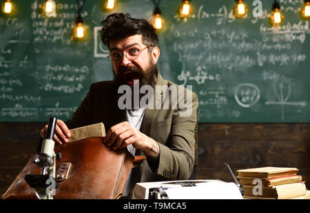 Surpris hipster mallette ouverte avec des papiers. Homme barbu avec un sac en papier de recherche. Businessman with beard dans les verres à 24. Scientifique de l'homme faire Banque D'Images