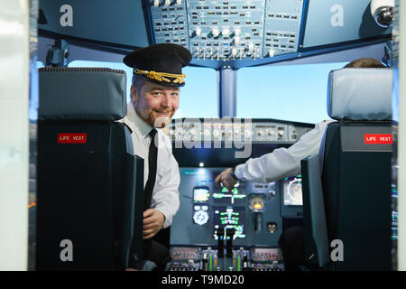 Barbu souriant pilot in cockpit Banque D'Images