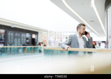 Homme entreprenant résoudre les questions de travail sur le téléphone Banque D'Images