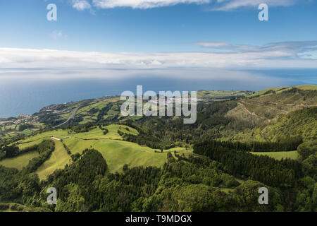 Vue sur le paysage aérien sur de vertes collines, des pâturages et de l'océan vu de Lagoa do Fogo (Lac/ Lagoon d'incendie) en direction de la côte sud de Sao Banque D'Images