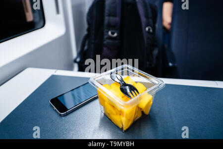 Salade de melon avec la fourche - voyage en train jusqu'au petit smartphone sur la table Banque D'Images