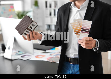 Jeune designer avec palettes de couleurs et de modèle de maison Banque D'Images