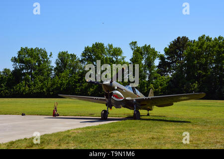 Un Curtiss P-40 Warhawk Flying Tiger avec insignia est stationné le long d'une piste gazonnée au cours d'un spectacle aérien de la DEUXIÈME GUERRE MONDIALE en Virginia Beach VA Banque D'Images