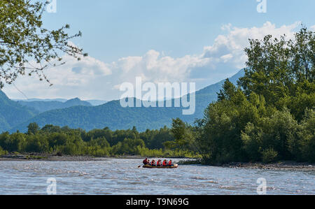 Rafting dans un gros bateau sur une rivière de montagne en été Banque D'Images