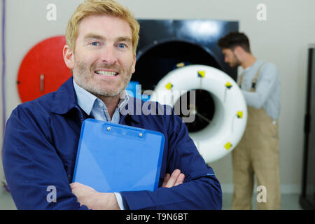 Portrait of a young engineer holding un presse-papiers Banque D'Images