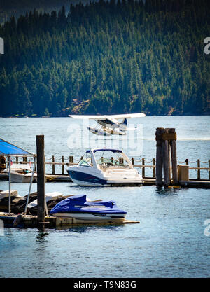 Une visite d'un hydravion décolle sur Lake Coeur d'Alene, près du trottoir flottant autour de la marina du complexe avec alpine et les montagnes à l'arrière Banque D'Images