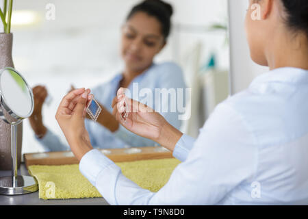 Belle Jeune femme tenant une paire de boucles Banque D'Images