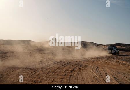 Course défi concours désert. Location de surmonter les obstacles de dunes de sable. Voiture conduit le tout-terrain avec des nuages de poussière. Véhicule hors route course obstacles dans wi Banque D'Images