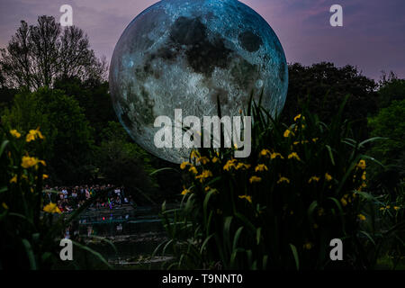 18 mai 2019 - Luke Jerram Artiste's 7 mètre de diamètre lune gonflable est suspendu au dessus de l'étang à Queen's Park à Brighton au cours du Brighton Festival. Le modèle lunaire éclairé est l'un des plusieurs exemplaires que tour le monde de Luke's exposition temporaire. Il dispose d'images de la NASA détaillées de la surface de la lune, avec tous les centimètres de la sphère éclairée représentant de 5km de l'moonâ de la terre. L'événement artistique libre fait partie du Brighton Festival, qui est une célébration annuelle de l'art, musique, théâtre, danse, cirque, et de la littérature, qui a lieu dans la ville de Brighton et Hove au cours de la m Banque D'Images