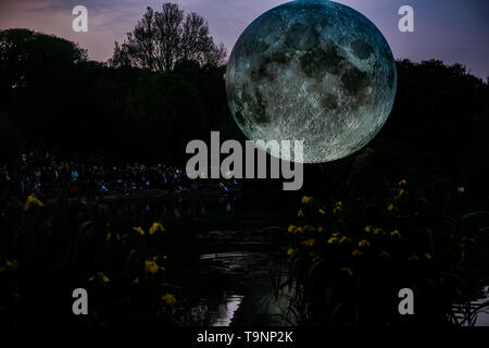 18 mai 2019 - Luke Jerram Artiste's 7 mètre de diamètre lune gonflable est suspendu au dessus de l'étang à Queen's Park à Brighton au cours du Brighton Festival. Le modèle lunaire éclairé est l'un des plusieurs exemplaires que tour le monde de Luke's exposition temporaire. Il dispose d'images de la NASA détaillées de la surface de la lune, avec tous les centimètres de la sphère éclairée représentant de 5km de la surface de la lune. L'événement artistique libre fait partie du Brighton Festival, qui est une célébration annuelle de l'art, musique, théâtre, danse, cirque, et de la littérature, qui a lieu dans la ville de Brighton et Hove au cours de la m Banque D'Images