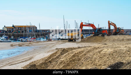 Lyme Regis, dans le Dorset, UK. 20 mai 2019. Météo France : une belle journée chaude et ensoleillée à Lyme Regis. Les véhicules de l'usine a frappé la plage populaire à Lyme Regis à sable replinish perdues au fil des mois d'hiver avant les vacances de banque et la moitié des vacances à long terme. Le sable est remplacé sur la populaire plage avant la saison touristique débute chaque année afin que les visiteurs puissent continuer à profiter de la jolie plage tout au long de l'été saison touristique. Credit : Celia McMahon/Alamy Live News. Banque D'Images