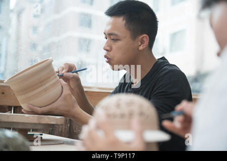 (190520) -- LONGQUAN, 20 mai 2019 (Xinhua) -- Chanson Lin travaille sur la base d'argile pour un brûleur d'encens celadon dans son studio de Longquan, est de la Chine, la province du Zhejiang, le 20 mai 2019. Né en 1993, Song Lin est originaire de Longquan, home to China's best celadon marchandises. Il a reçu une formation professionnelle à la fois dans sa ville natale et Jingdezhen, un autre important hub porcelaine de Chine. Lin avait également suivi d'autres artisans celadon pendant des années avant la mise en place d'un studio à la maison en 2014, l'accent sur la reproduction d'encens celadon classique. La collection personnelle de lin est passé à plus de 40 celadon Banque D'Images