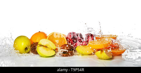 Fruits frais avec les projections d'eau sur fond blanc Banque D'Images