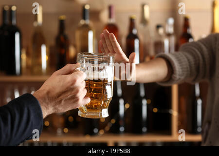 Homme avec bière et d'une femme refusant de verre au bar Banque D'Images