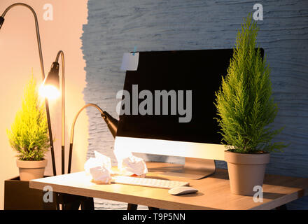 Pots avec du citron cyprès dans la chambre avec bureau confortable Banque D'Images