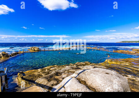 Les nageurs dans la piscine dans les rochers, au nord de Maroubra Beach à Sydney, Australie Banque D'Images