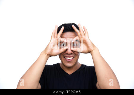 L'hispanic man doing ok avec choqué geste surpris le visage, les yeux regardant à travers les doigts isolé sur fond blanc. Concept L'expression du visage. Banque D'Images