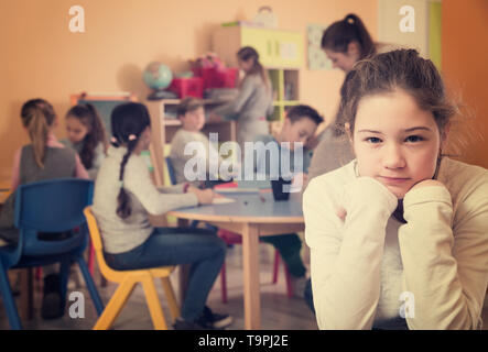 Portrait de triste fille brune et les enfants en classe de dessin Banque D'Images