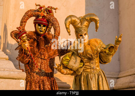 Portraits d'un couple masqué dans de beaux costumes, arlequin créative posant devant un mur en marbre, célébrer le carnaval vénitien Banque D'Images