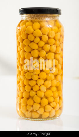 Pois chiches bouillis dans un bocal en verre sur un fond blanc Banque D'Images