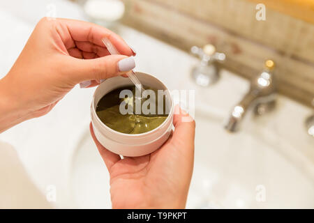 Fille avec une pincette sort eye patches à partir de la boîte de dialogue. Matin spa concept. Banque D'Images