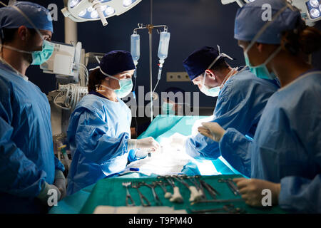 Groupe de chirurgiens occupé sur la table d'opération Banque D'Images