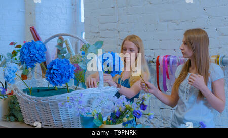 Deux femmes fleuristes, faire de gros panier de fleurs floral flower shop Banque D'Images