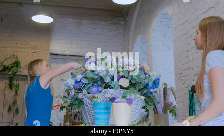 Deux femmes fleuristes, faire de gros panier de fleurs floral flower shop Banque D'Images