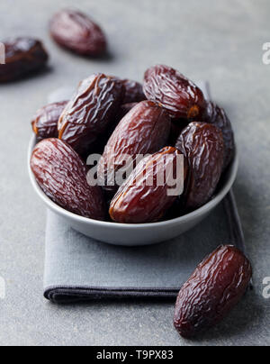 Medjool dates frais dans un bol. Fond gris. Close up. Banque D'Images