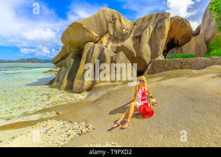 De vie attrayant, femme avec un joli chien aime à Anse Source d'argent l'une des plus belles plages de La Digue, Seychelles célèbre pour crystal Banque D'Images