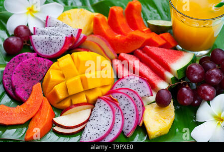 Assortiment de fruits tropicaux avec du jus de feuille de palmier, arrière-plan. Vue d'en haut. Close up. Banque D'Images