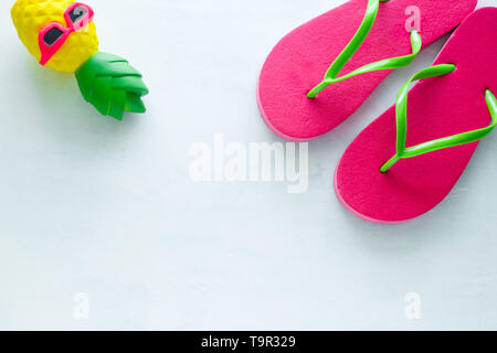 Pink Beach tongs et spongieux toy en ananas sur fond blanc lunettes copy space Banque D'Images