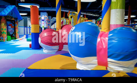 Libre de droit des enfants colorés et carousel swing sur le terrain de jeux couvert de tapis doux pour la sécurité des enfants Banque D'Images