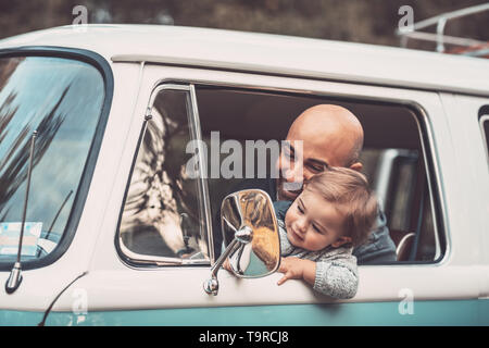 Petit garçon avec père s'amusant dans la voiture, papa et son fils s'asseoir dans le siège du conducteur dans le van, jouer et à la recherche pour le rétroviseur, heureux fam Banque D'Images