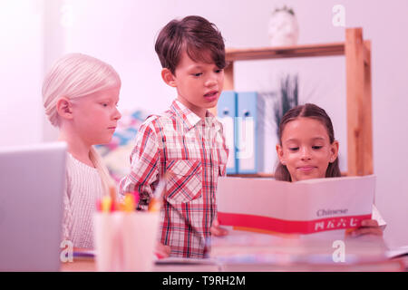 Deux filles et un garçon à apprendre le chinois. Banque D'Images