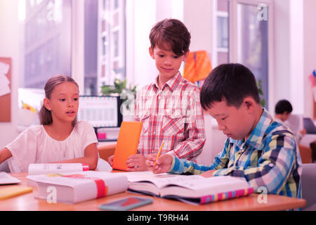 Deux garçons et une fille à la leçon. Banque D'Images